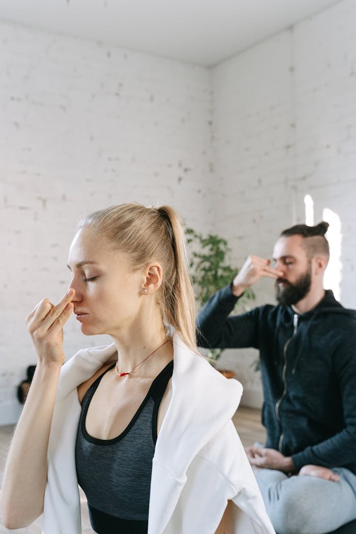 Mastering the First Impression: Your intriguing post title goes here A man and woman perform breathing exercises in a serene indoor yoga session.